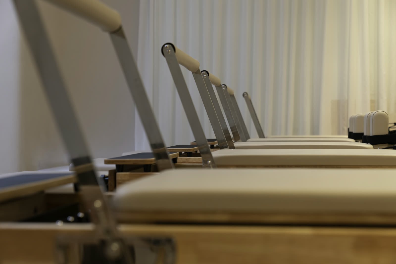 A row of reformer machines lined up along the studio floor at Studio 8, New Cairo